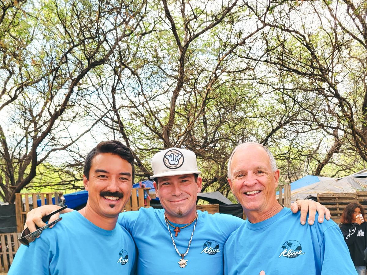 SFC surf instructors smiling together beneath the trees near Waikīkī